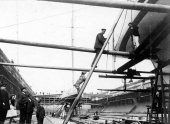 700-Sir Thomas Lipton going aboard Shamrock III in dry dock. Mike the dog insists on following. April 1903.